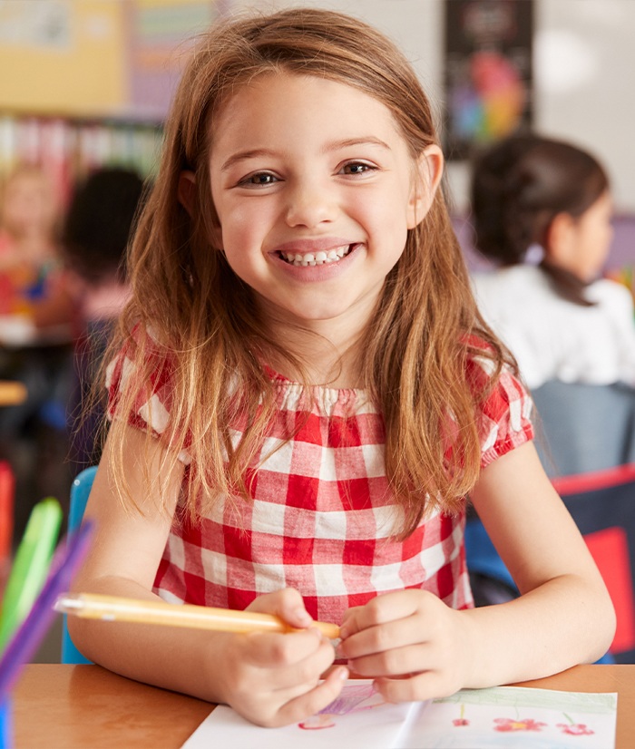 Child sharing healthy smile after visiting her board certified pediatric dentist