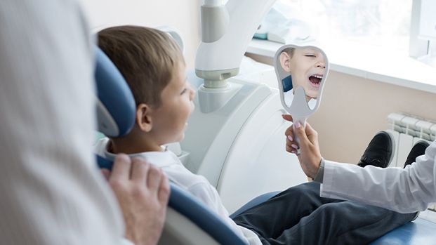 Child looking at smile after pediatric dentistry visit