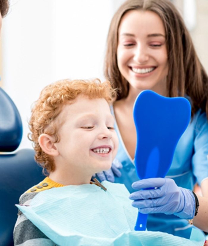 Young boy smiling after tooth-colored filling 