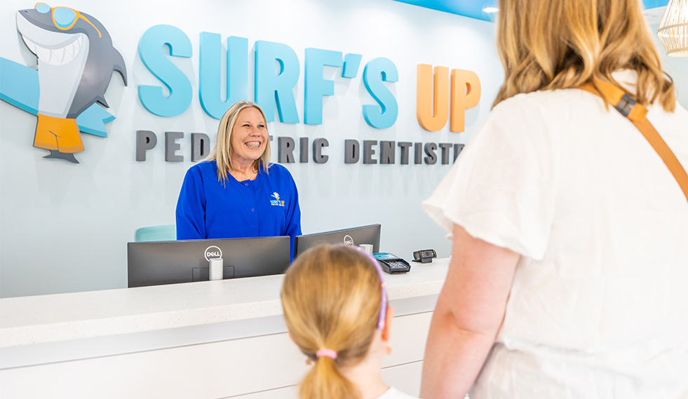 Family checking in at dental office reception desk