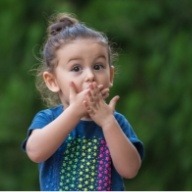 Little girl in need of emergency dentistry covering mouth in pain