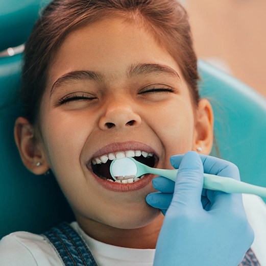 Little girl having smile examined by emergency dentist in Papillon, NE