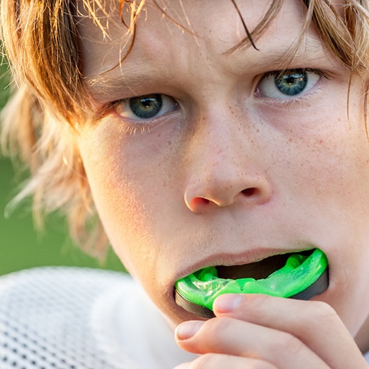 Boy wearing mouthguard from emergency dentist in Papillon, NE