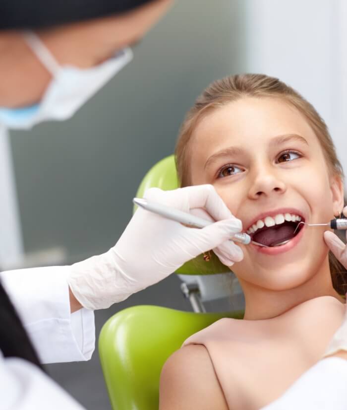 Dentist examining child's tooth colored filling