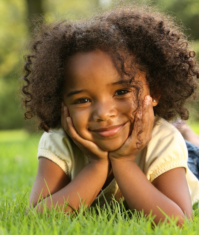Child smiling after pediatric dental crown restoration