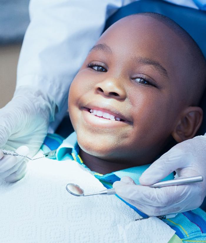 Child smiling while relaxing in treatment chair before checkup