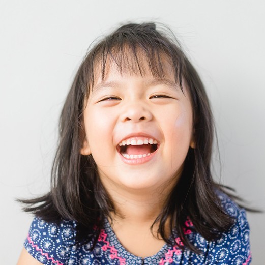 a toddler laughing before visiting their pediatric dentist in Papillion