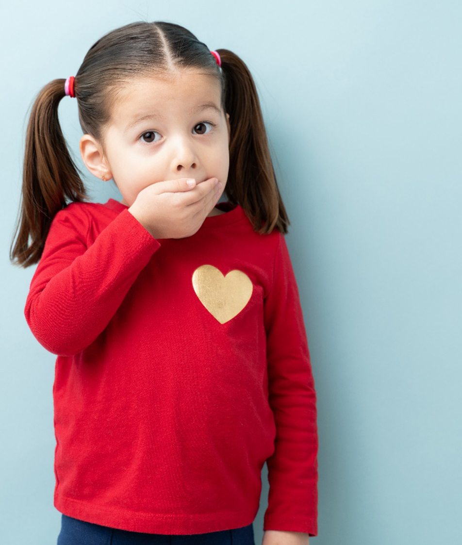 toddler covering mouth from pediatric dentist in Papillion