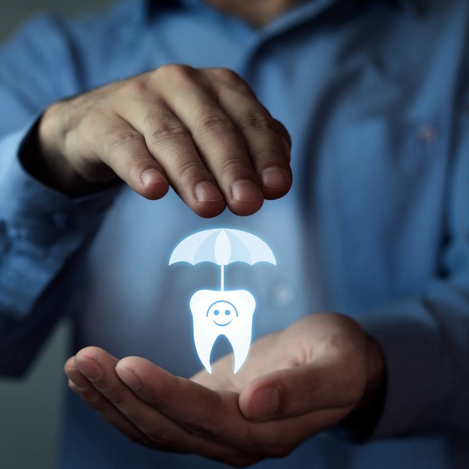 A man’s hands over a CGI of a tooth with an umbrella