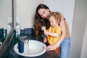 parent encouraging child to brush teeth  