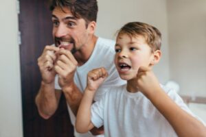 Father showing son how to floss