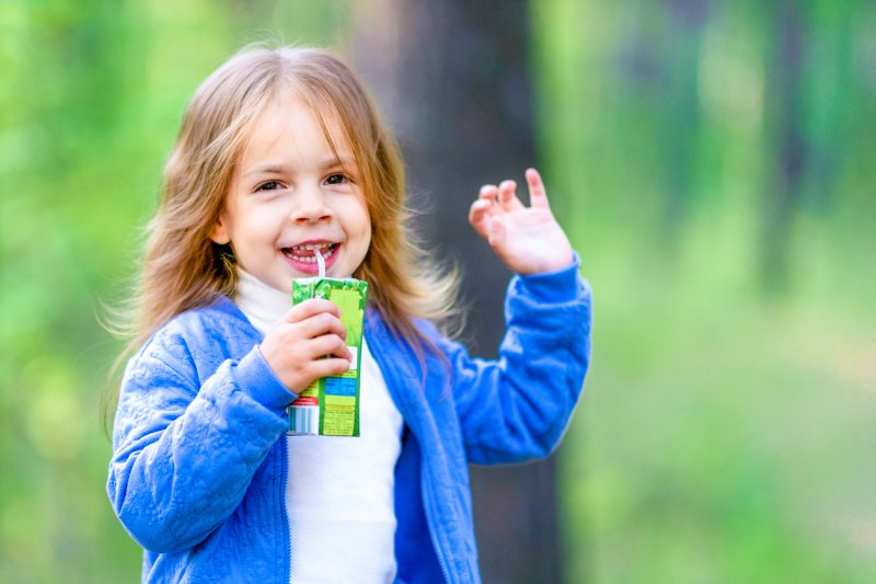 little girl holding a juice box