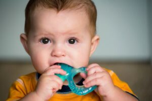 Baby chewing on teething ring. 