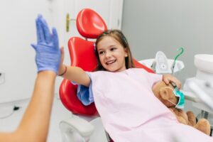 Young girl high-fiving her dentist